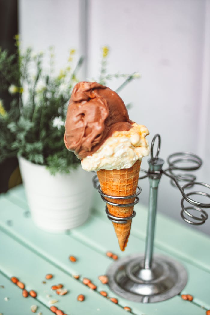 Close-up of a chocolate and vanilla ice cream cone on a stand outdoors.